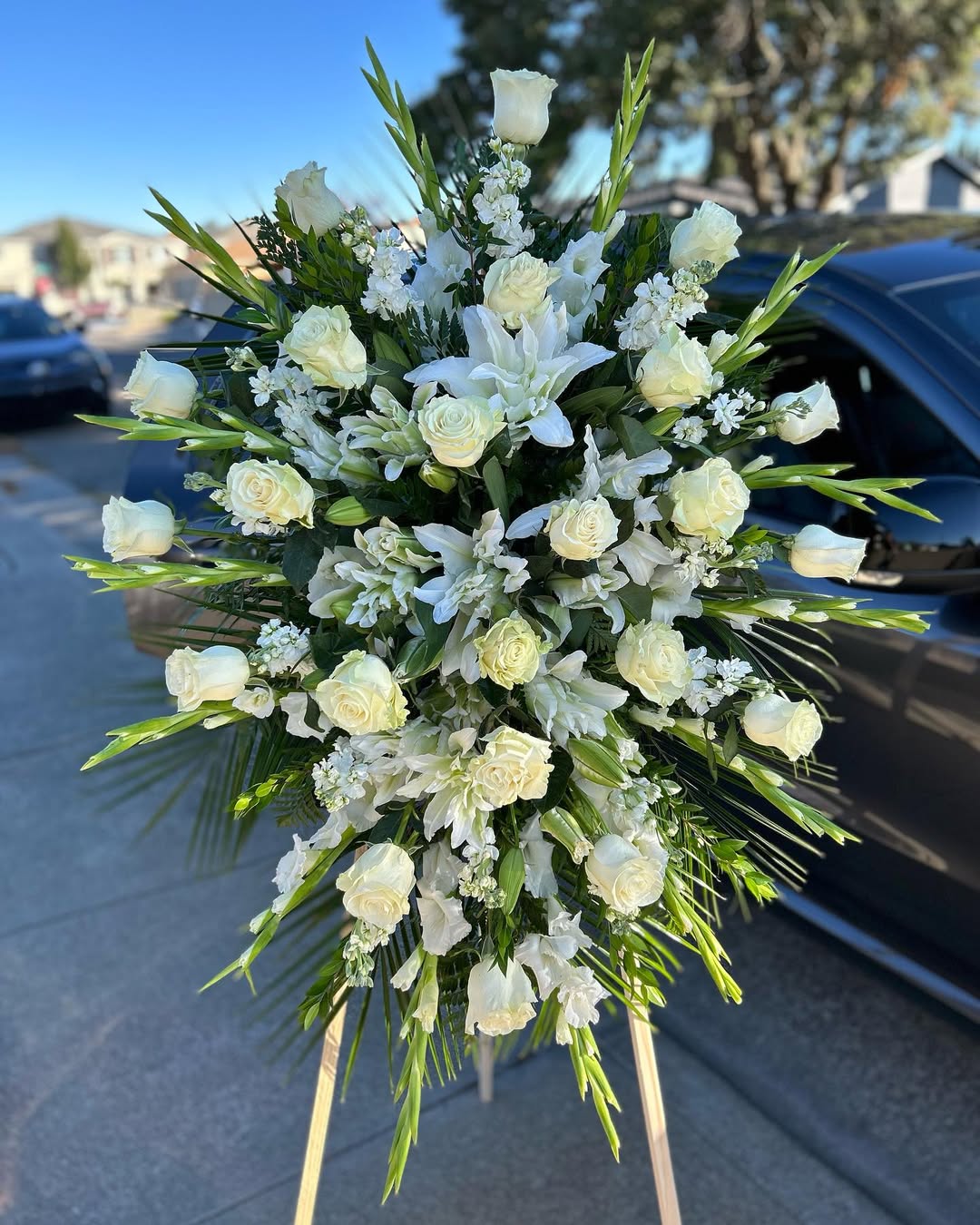 Bouquet of white flowers on a car hood with a street and buildings in the background