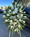Bouquet of white flowers on a car hood with a street and buildings in the background