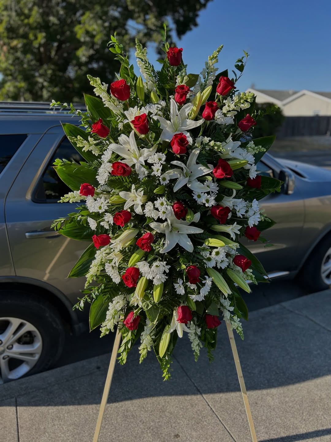 Bouquet of white flowers on a car hood with a street and buildings in the background